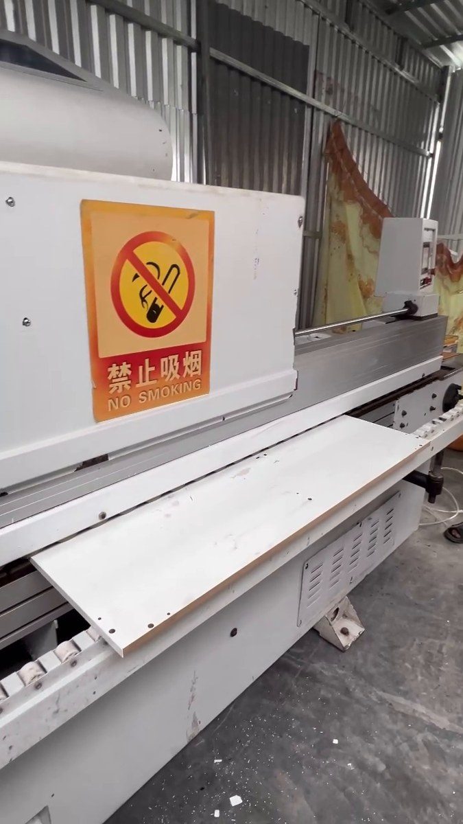 máy dán cạnh trong dây chuyền CNC cưa bàn trượt hình thực tế